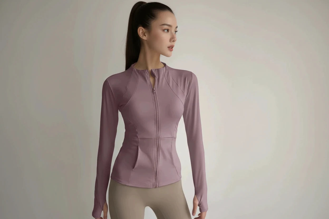 Pink long-sleeve athletic jacket worn by a person on a plain background